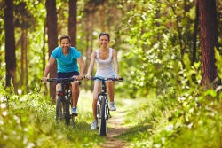 Young couple riding bicycles in natural environment